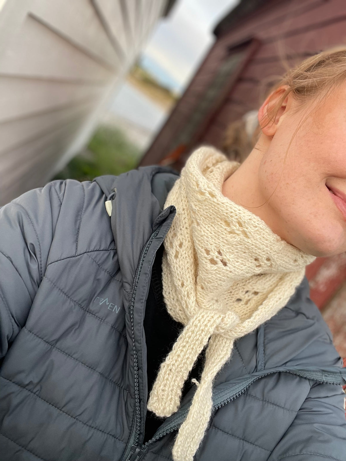 Person med et lyst håndstrikket skjerf fra Mønsteridyll